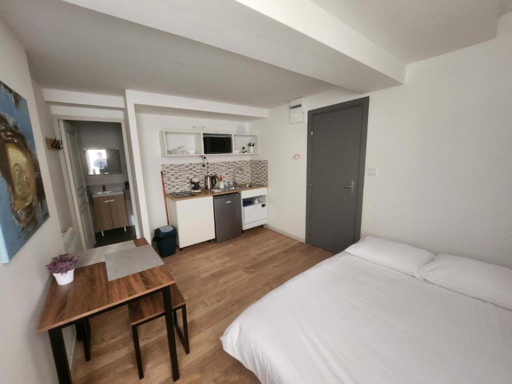 um quarto com uma cama, uma mesa e uma cozinha em Pied à terre tout confort em Bar-le-Duc