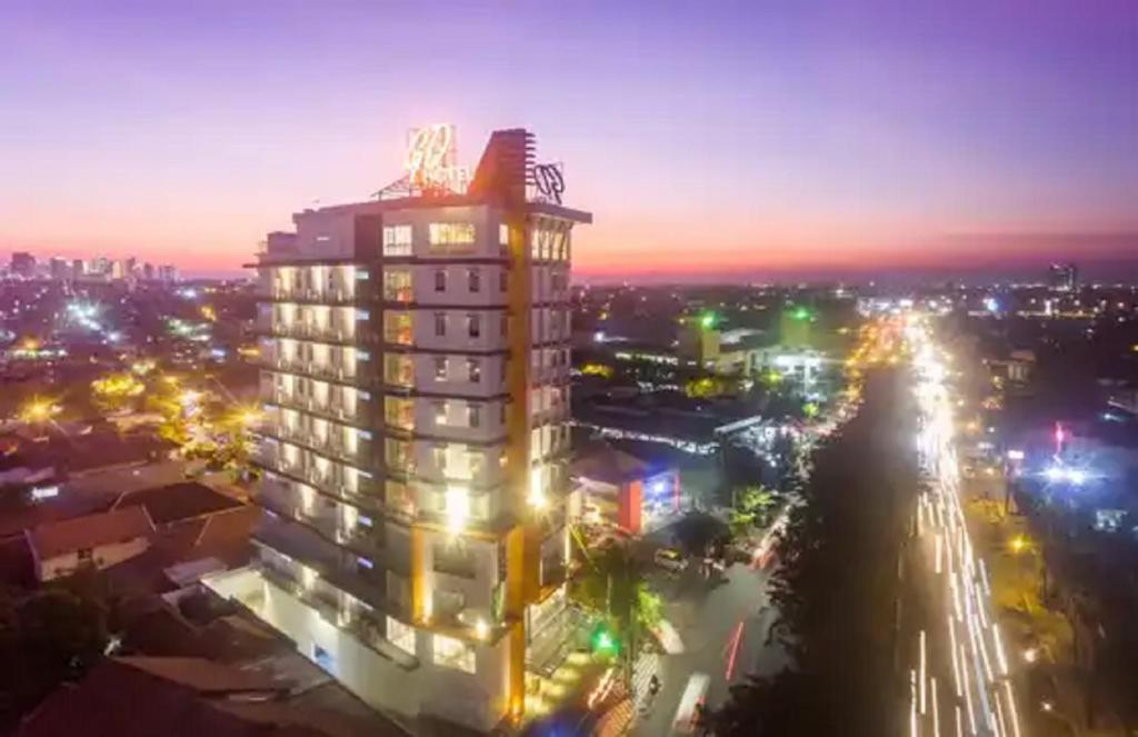 un grand bâtiment de nuit avec une ville dans l'établissement Great Diponegoro Hotel Surabaya, à Surabaya