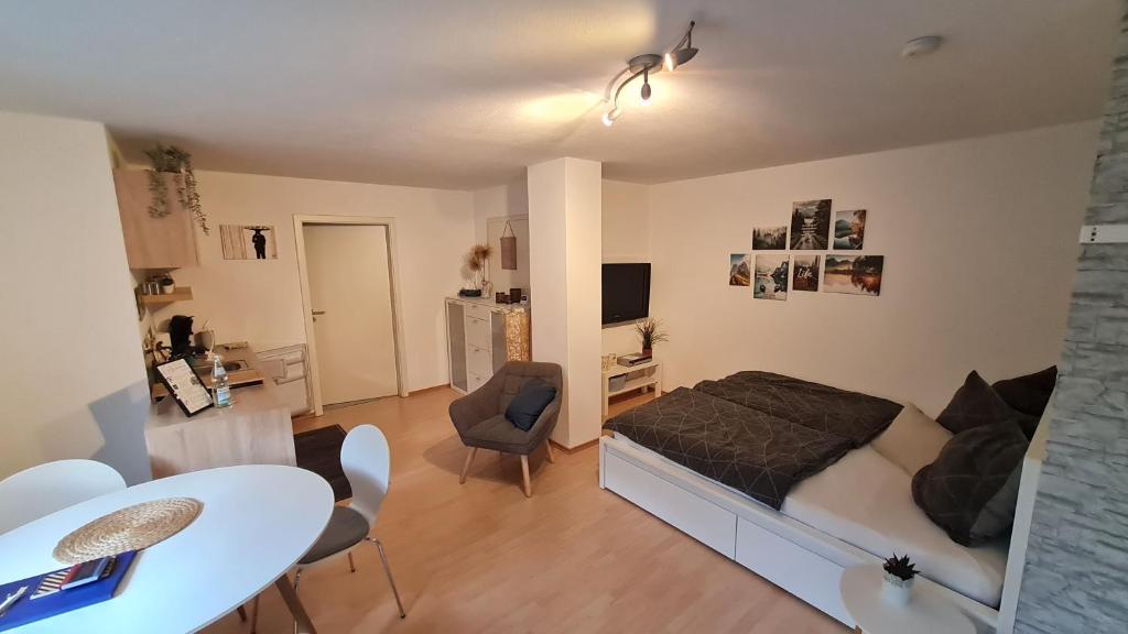 a bedroom with a bed and a table and a dining room at Schöne Souterrain Wohnung (WLAN/Parken kostenlos) in Riegel