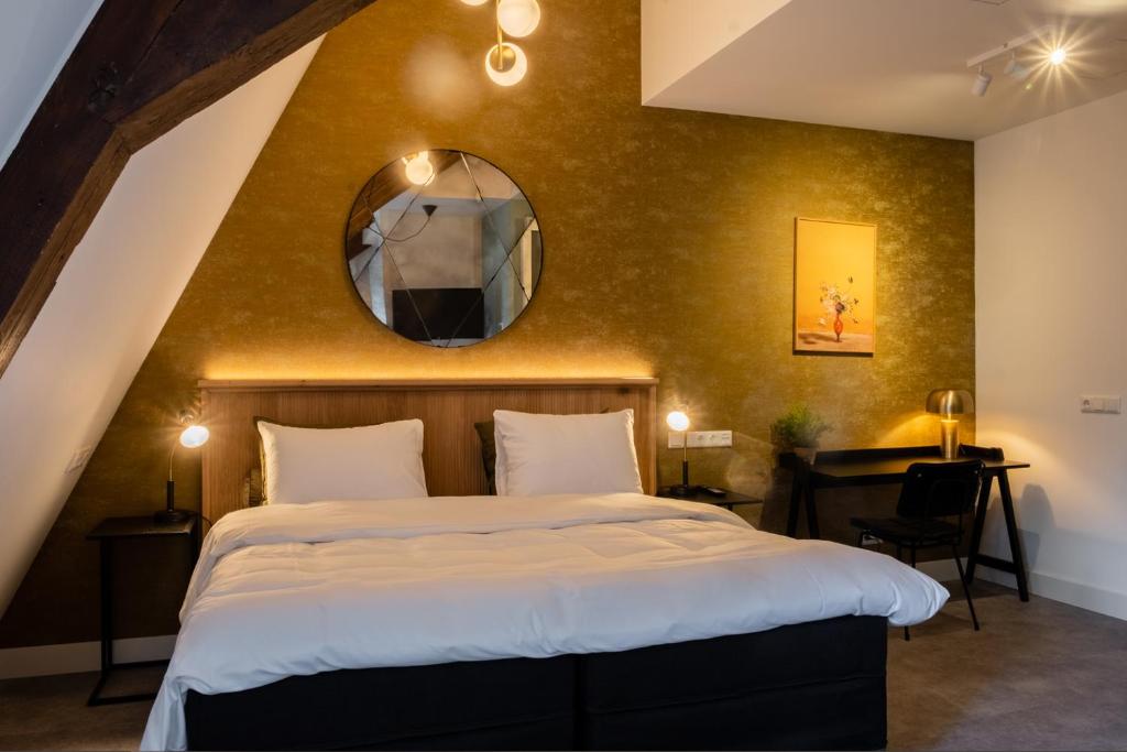 a bedroom with a large bed and a mirror at Hotel Botanique Breda in Breda