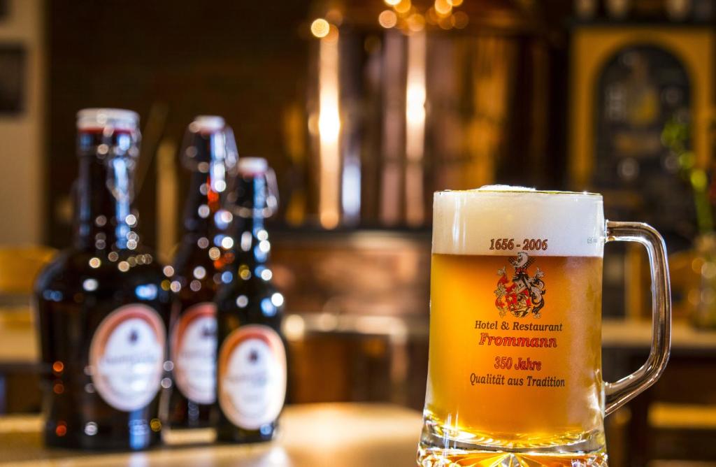 een glas bier zittend op een tafel met bierflessen bij Frommanns Landhotel in Buchholz in der Nordheide