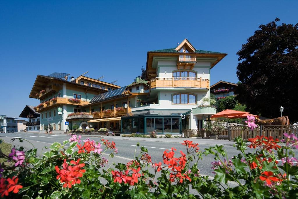 un bâtiment fleuri en face d'une rue dans l'établissement Hotel Gasthof Obermair, à Fieberbrunn