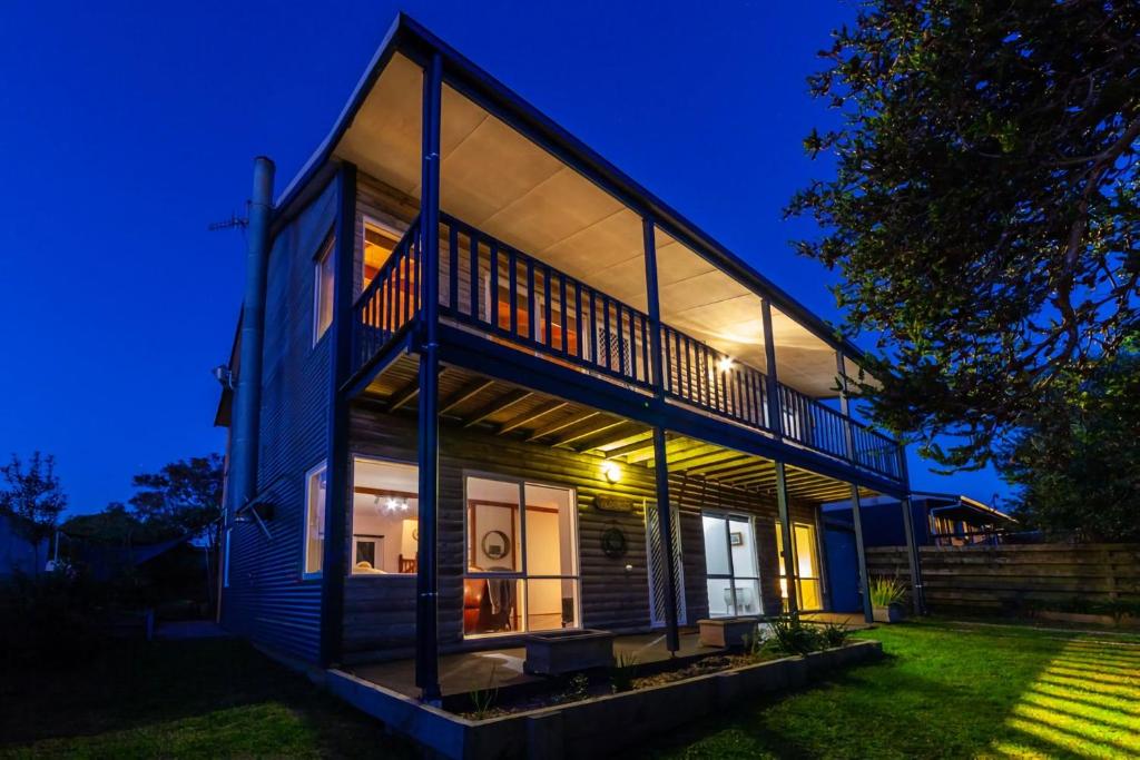 uma casa com uma fachada de vidro à noite em The Albatross em Port Campbell