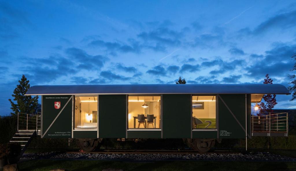 una casita verde con techo azul en LokoMotel-Waggon, Luxus Appartment im Eisenbahnwaggon, en Stadtlohn