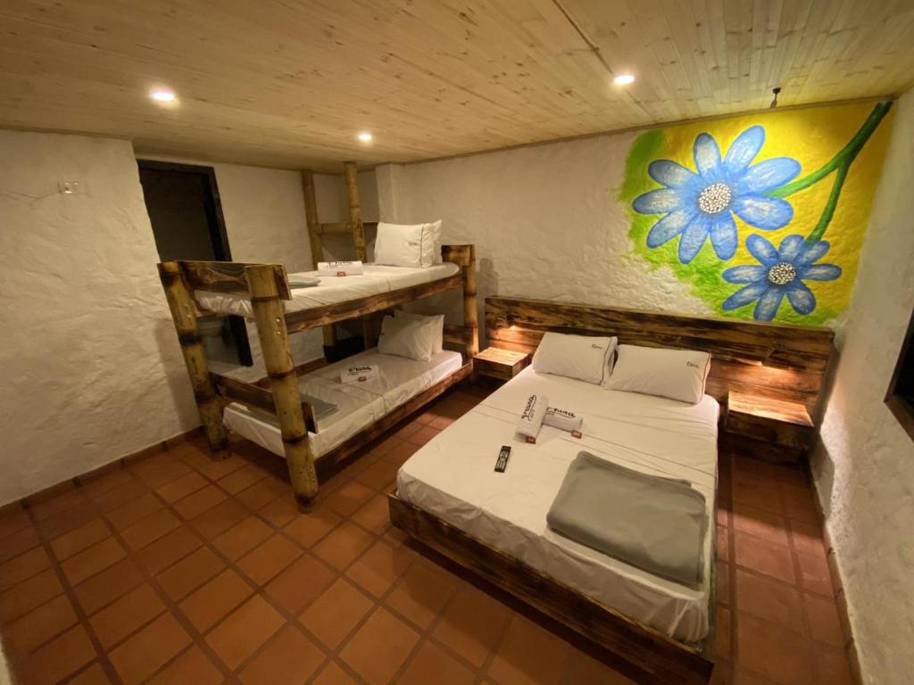 Cette chambre comprend deux lits et un tableau mural. dans l'établissement Prana, à San Gil