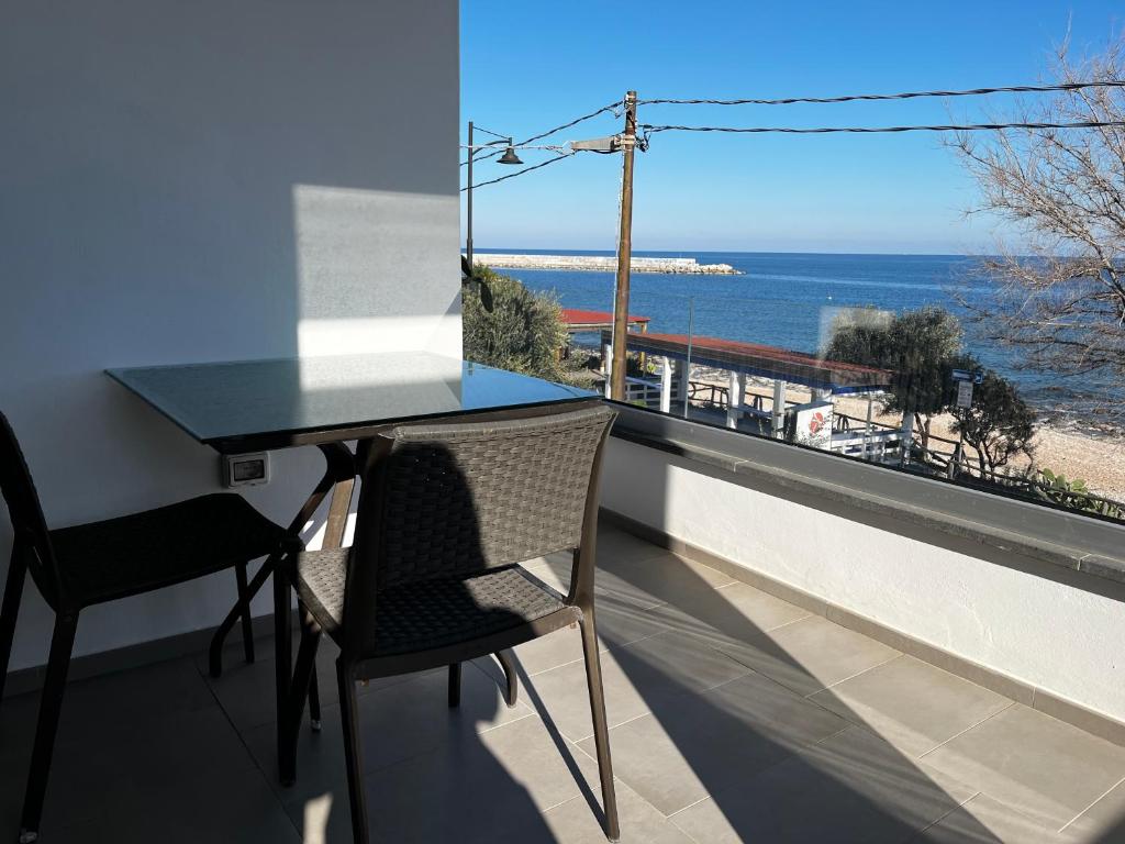 d'une table et de chaises sur un balcon avec vue sur l'océan. dans l'établissement Fronte mare, à Cala Gonone