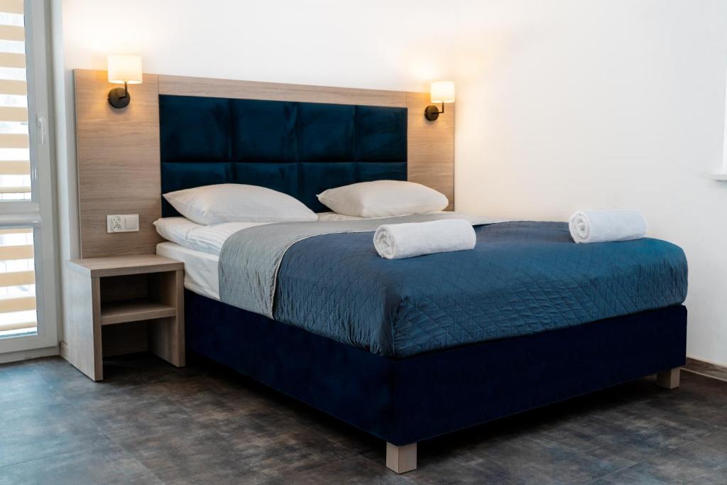 una camera da letto con un grande letto blu con due cuscini di Lynks Resort a Ustrzyki Dolne