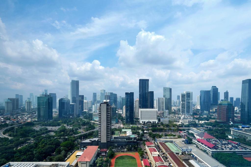 eine Skyline der Stadt mit hohen Gebäuden in der Ferne in der Unterkunft The Ritz-Carlton Jakarta, Pacific Place in Jakarta