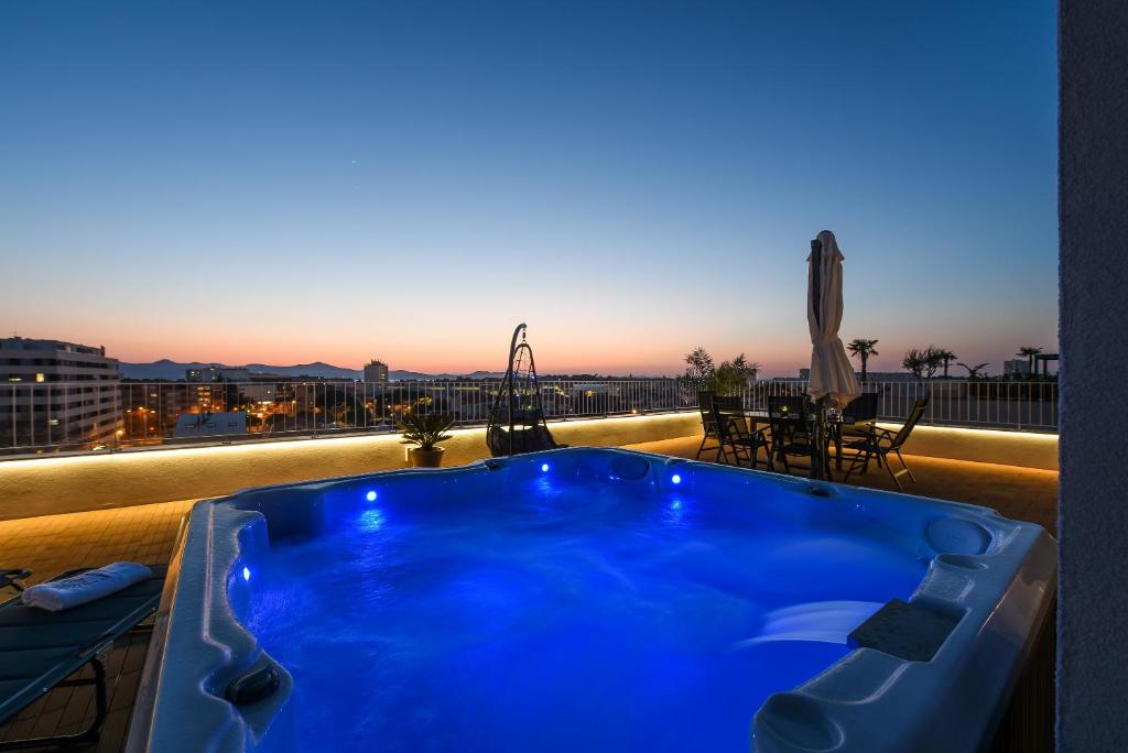 uma banheira de hidromassagem azul numa varanda com vista em Zadar Sunset Penthouse with spectacular view and jacuzzi em Zadar