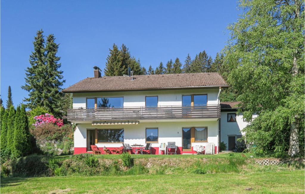 ein großes weißes Haus mit roten Stühlen im Hof in der Unterkunft Gorgeous Apartment In Lenzkirch-Saig With Kitchen in Lenzkirch