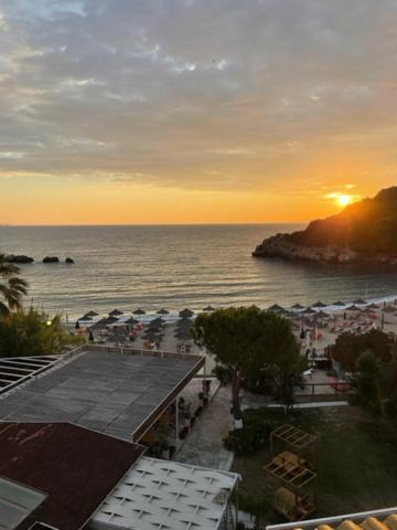 Blick auf einen Strand mit Sonnenuntergang über dem Meer in der Unterkunft Alex Bar APARTMENTS SARAKINIKO in Parga