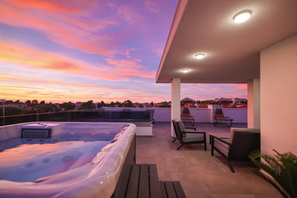 una vasca idromassaggio su un balcone con vista sul tramonto di Leonardo Luxury Residence 2 Penthouse with jacuzzi a Zara (Zadar)