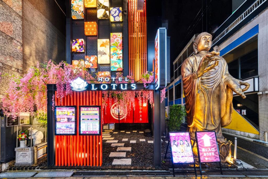 een standbeeld van een man met een surfplank voor een gebouw bij Hotel Lotus Umeda -Adult Only in Osaka