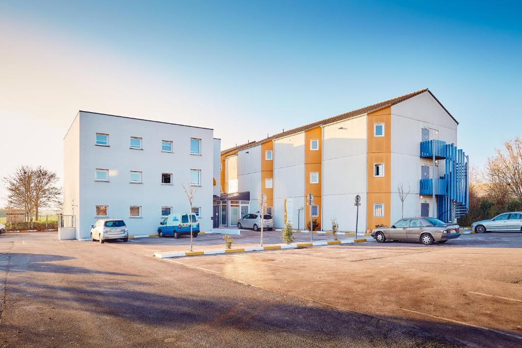 un parcheggio con auto parcheggiate di fronte a un edificio di Première Classe Amiens ad Amiens