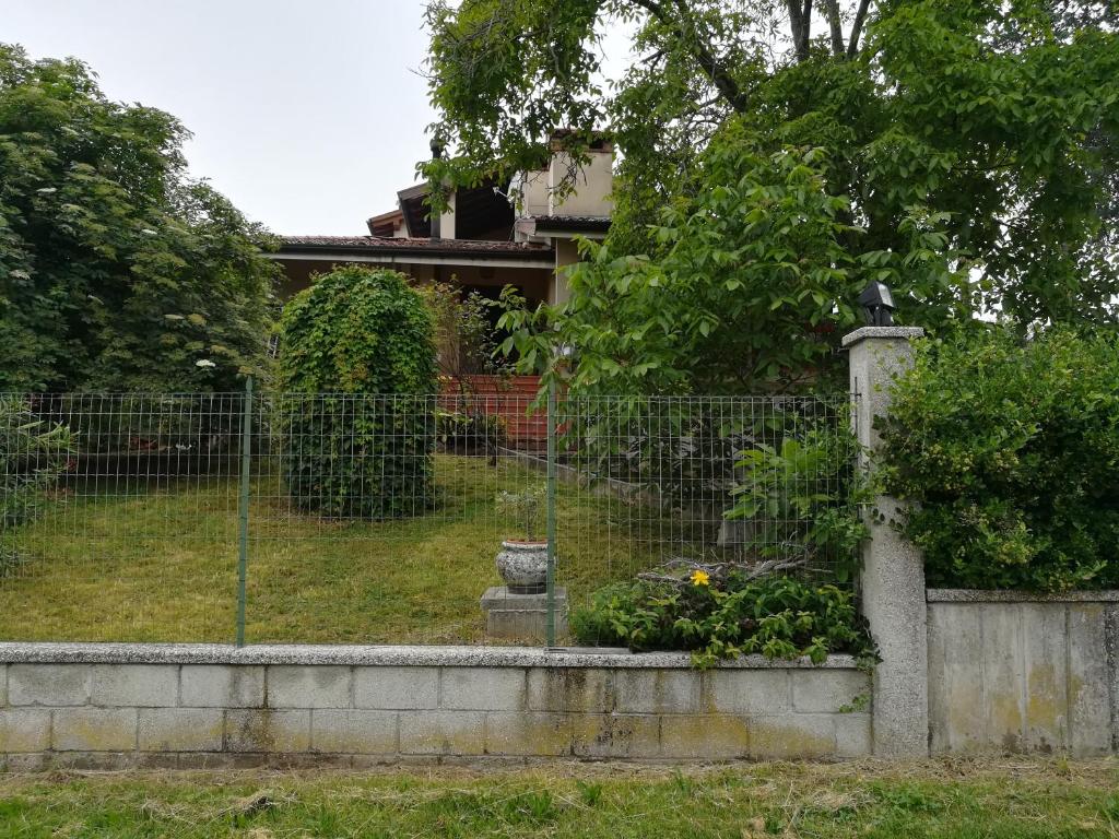 a fence in front of a house with flowers at Falco Bianco in San Daniele del Friuli