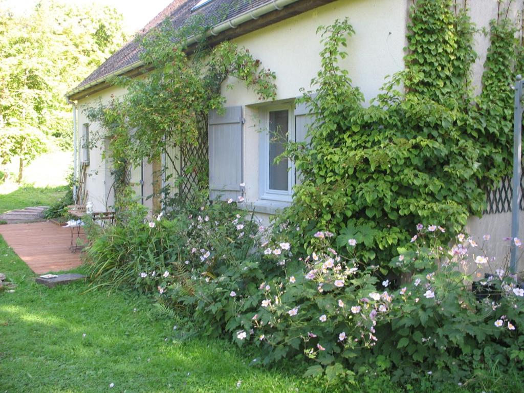 Le Brame - Chambres d'Hôtes في Avilly-Saint-Léonard: منزل أبيض مع نافذة وبعض الزهور