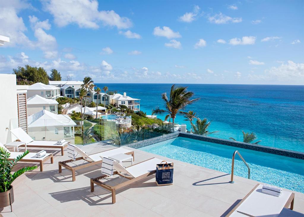 a resort swimming pool with a view of the ocean at Azura Bermuda in Bermuda