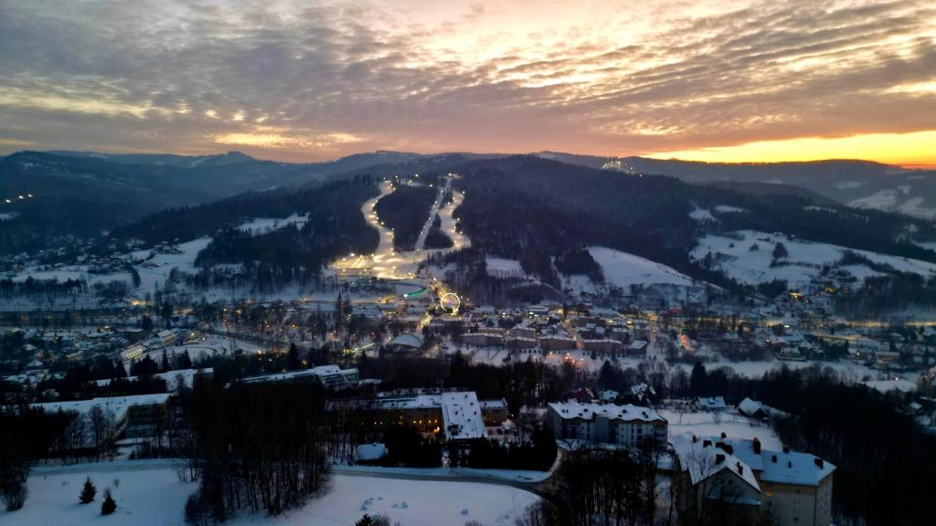 Blick auf eine Stadt im Schnee bei Sonnenuntergang in der Unterkunft Krokus in Wisła