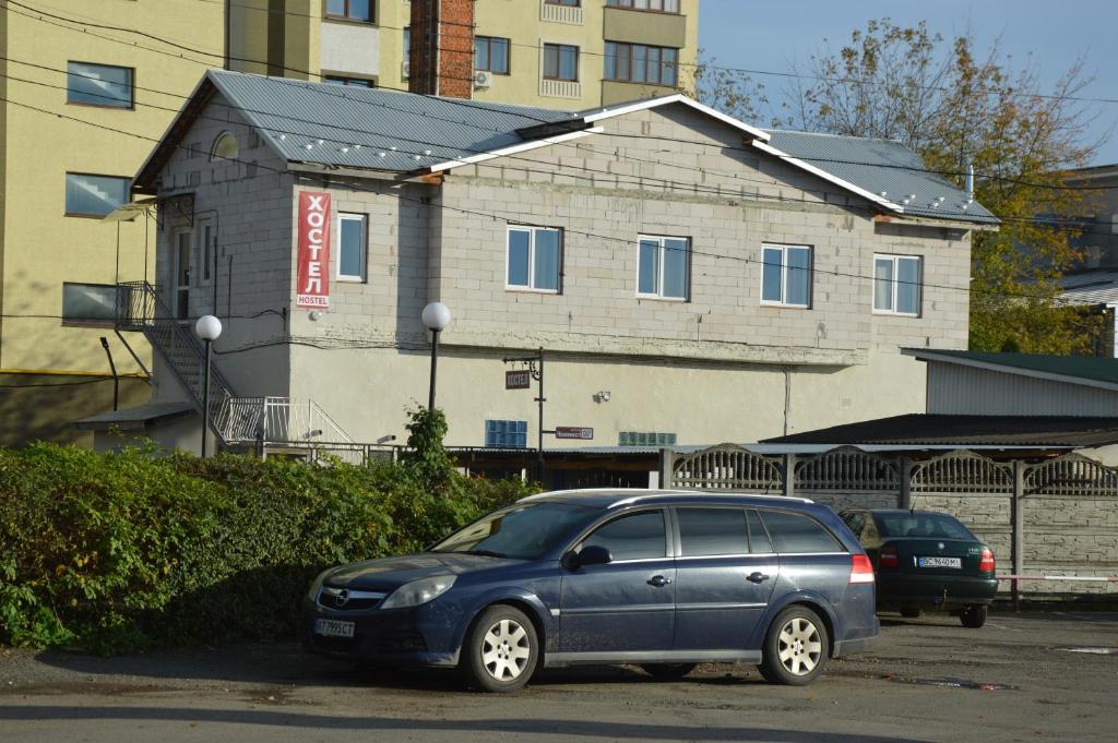 une voiture bleue garée devant un bâtiment dans l'établissement Хостел ПІД ФІКУСОМ, à Ivano-Frankivsk