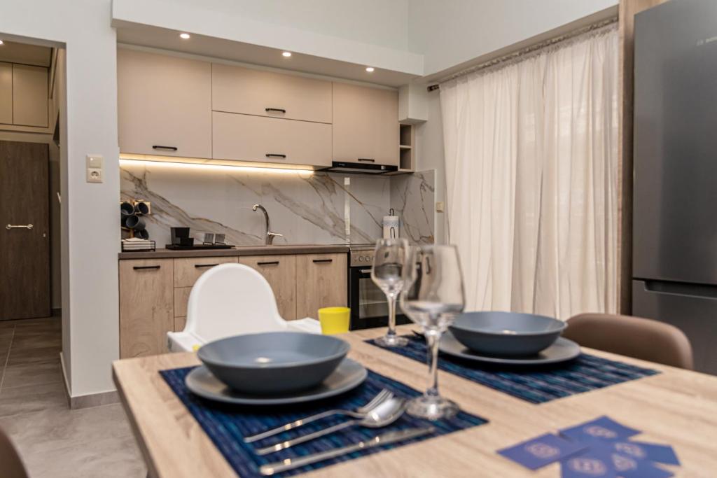 een keuken met een tafel met twee kommen en wijnglazen bij P&K LUXURY APARTMENTS 2 in Kalamata