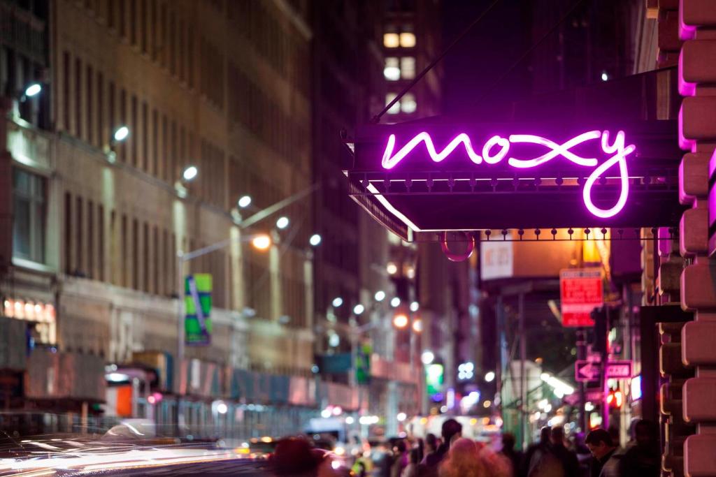 een neonbord op een stadsstraat 's nachts bij MOXY NYC Times Square in New York