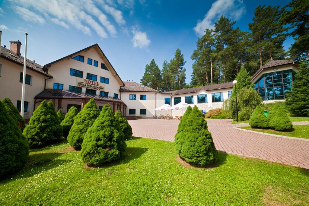 una fila di alberi di fronte a un edificio di Hotel Perła Bieszczadów Geovita a Czarna