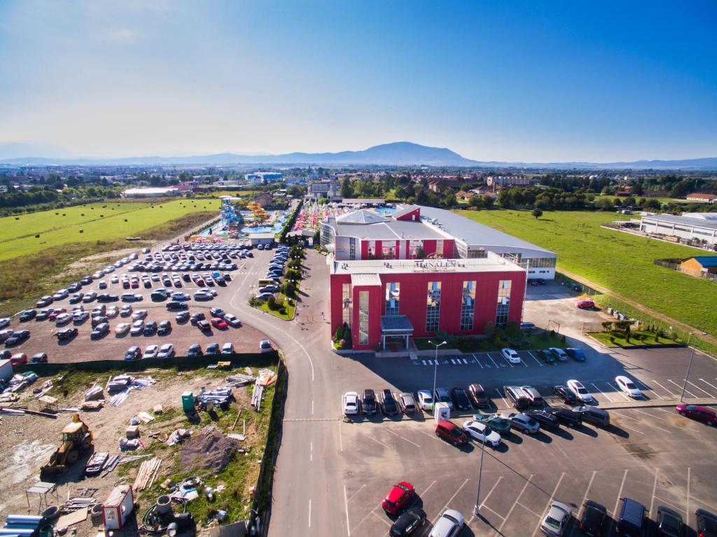 une vue aérienne sur un parking avec un bâtiment rouge dans l'établissement Hotel Alinalex - Paradisul Acvatic, à Braşov