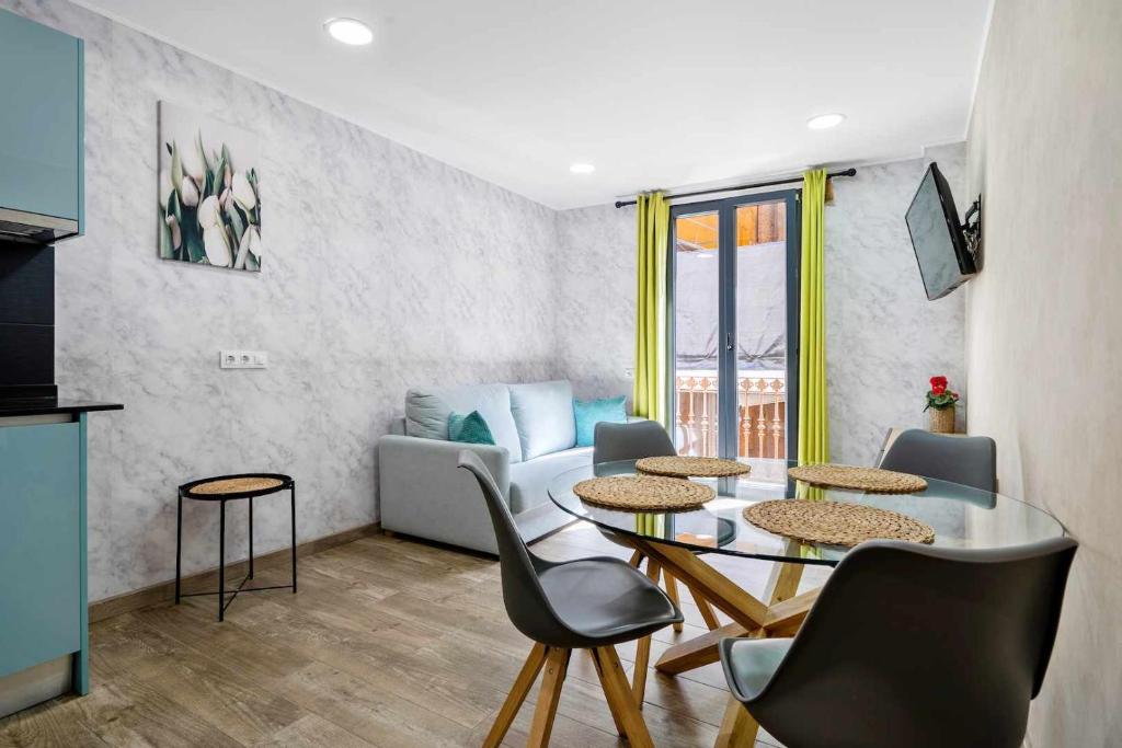 uma sala de estar com uma mesa e cadeiras e um sofá em Apartments Lilia Reus em Reus