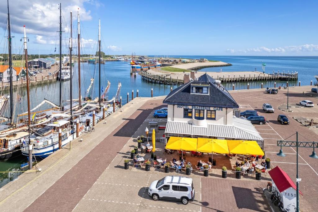 widok na przystań z budynkiem z ludźmi siedzącymi na zewnątrz w obiekcie Havenhotel At Sea Texel w mieście Oudeschild