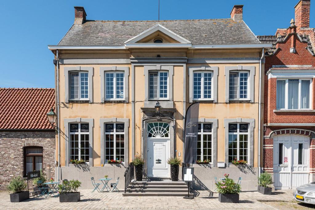 een groot geel huis met een witte deur bij Boutique hotel Sies in Watervliet