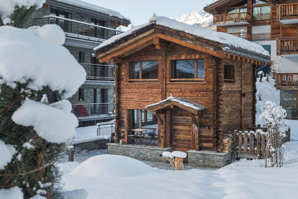 ein Blockhaus im Schnee mit Schnee in der Unterkunft Piccola Fiamma by Pizzo Fiamma in Zermatt