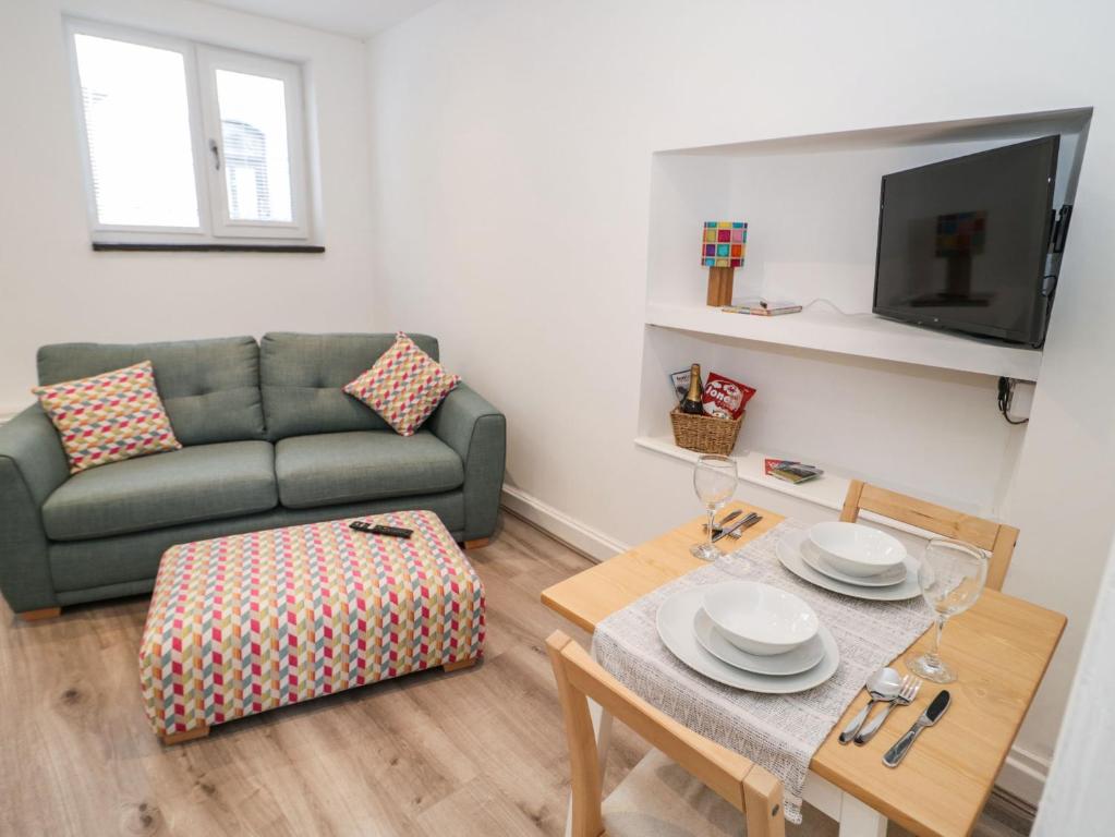 a living room with a couch and a table at Tŷ Capel Bach in Bangor