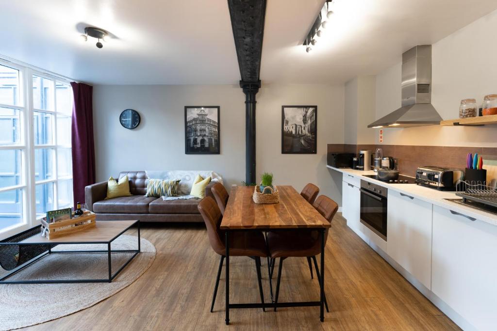 cocina y sala de estar con mesa y sofá en High Street Town House, en Mánchester