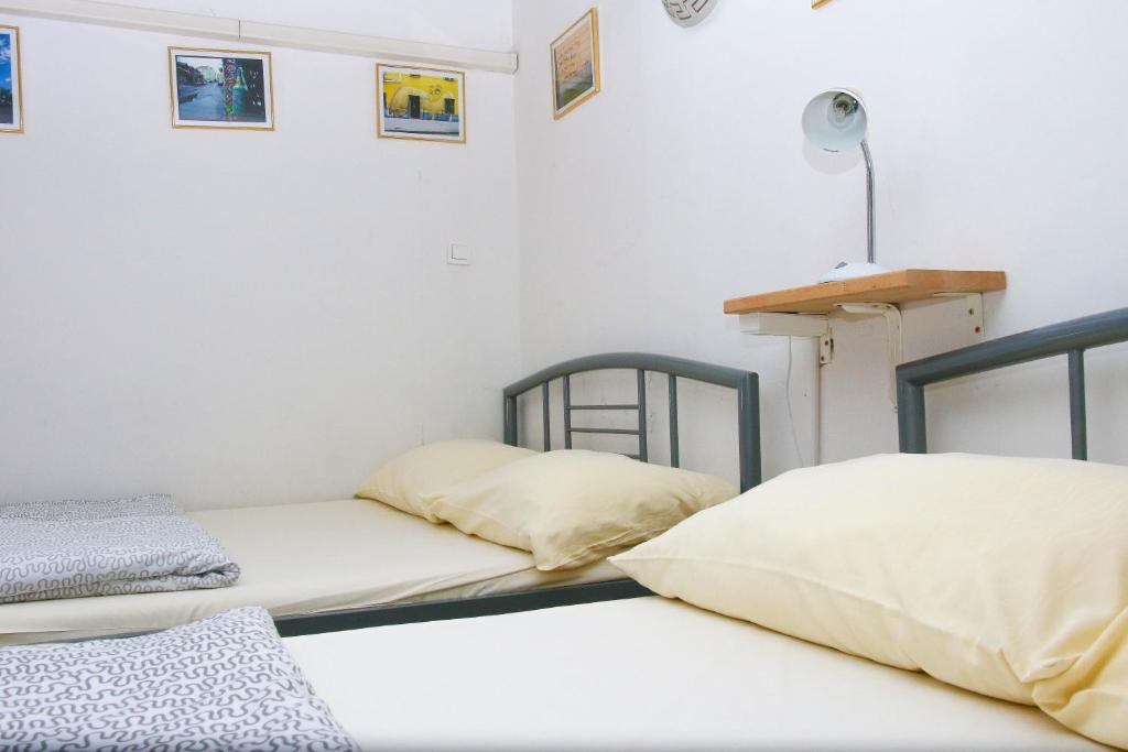 duas camas sentadas uma ao lado da outra num quarto em Hostel 24 em Liubliana