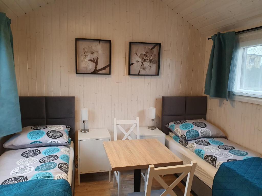 een kamer met twee bedden en een tafel erin bij Pokoje Babie Lato in Wrocław