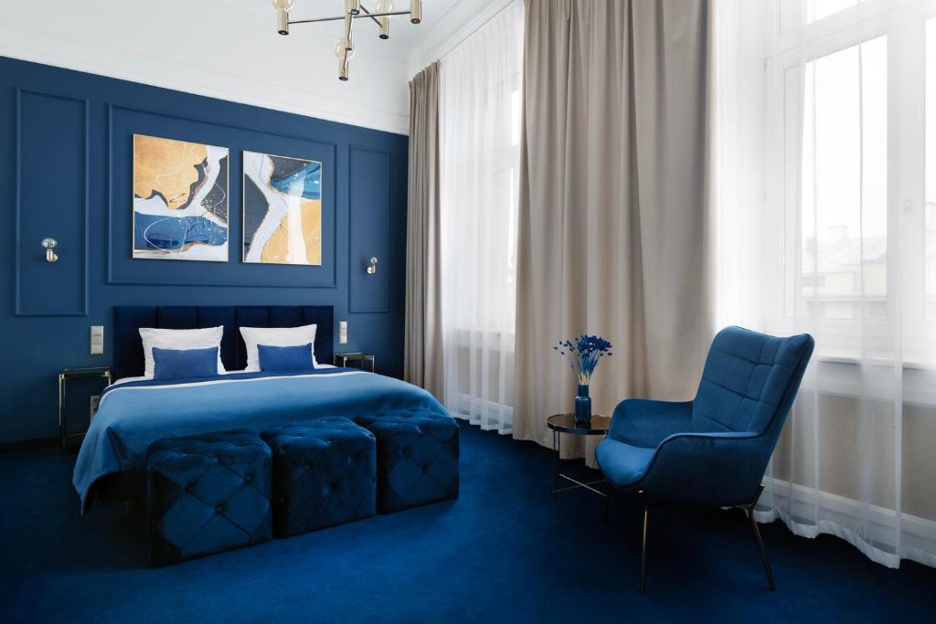 una camera blu con un letto e una sedia blu di IBB Hotel Grand Hotel Lublin a Lublino