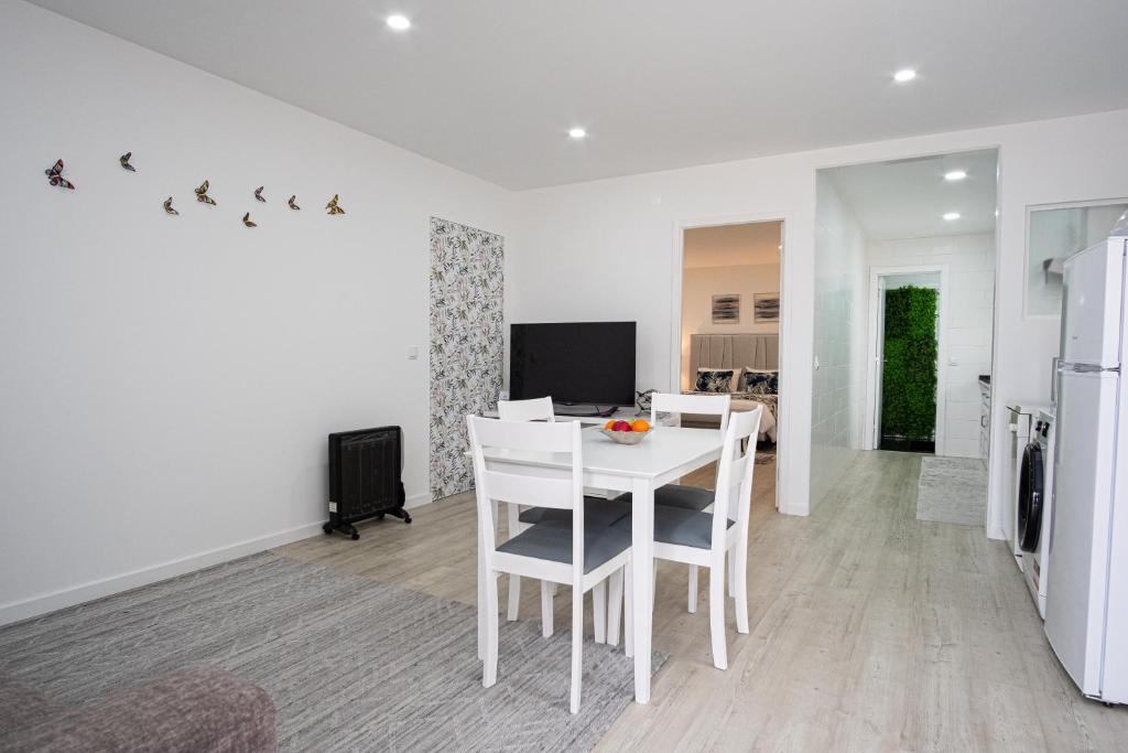 a kitchen and dining room with a white table and chairs at Casa Fonte Nova in Nazaré