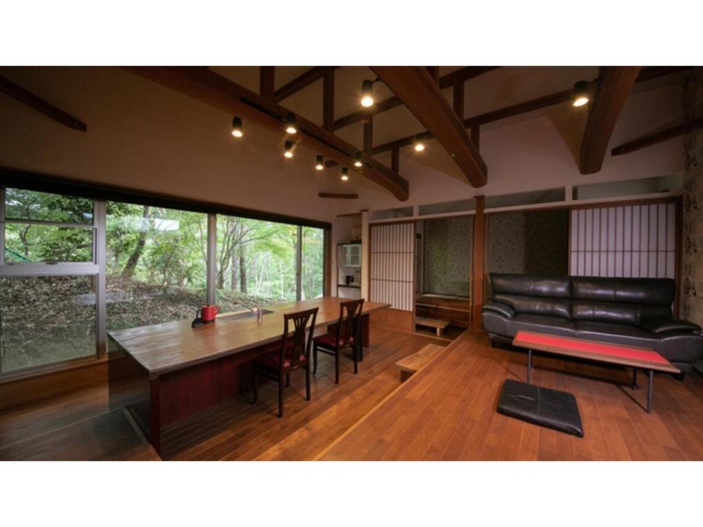 uma sala de estar com uma mesa e um sofá em Innterhill Tsubasa Yufuin - Vacation STAY 94230v em Yufu