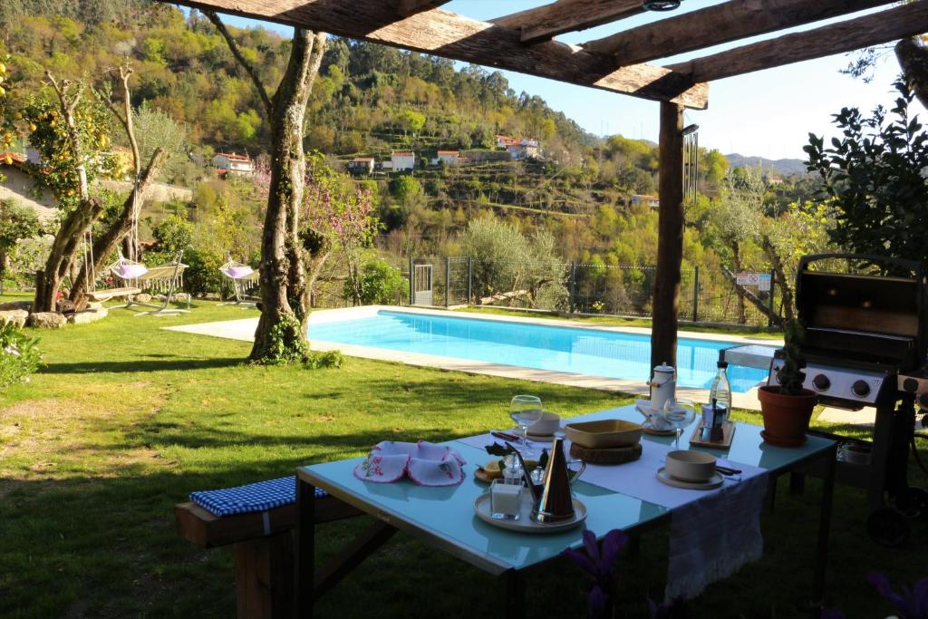 - une table avec de la nourriture à côté de la piscine dans l'établissement Vila de Campos - Gerês, à Vieira do Minho