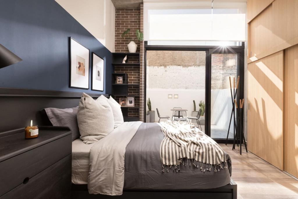 a bedroom with a bed and a large window at Punto Panamericano in Guadalajara