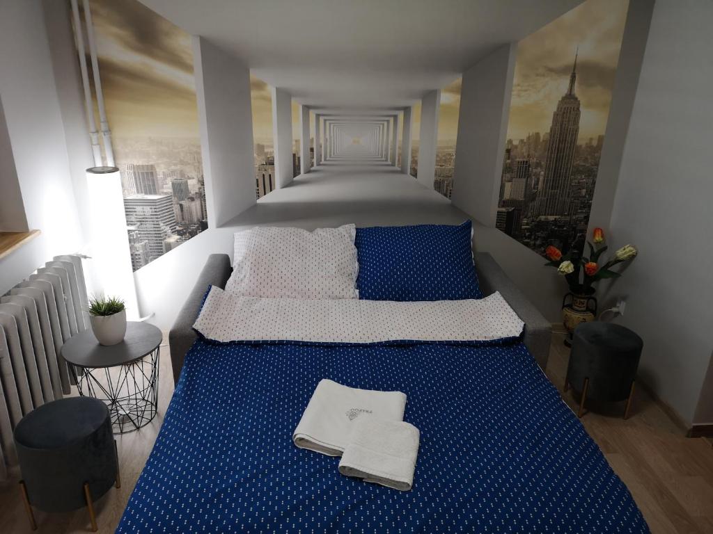 1 dormitorio con cama azul y vistas a la ciudad en Apartament przy dworcu, en Krosno