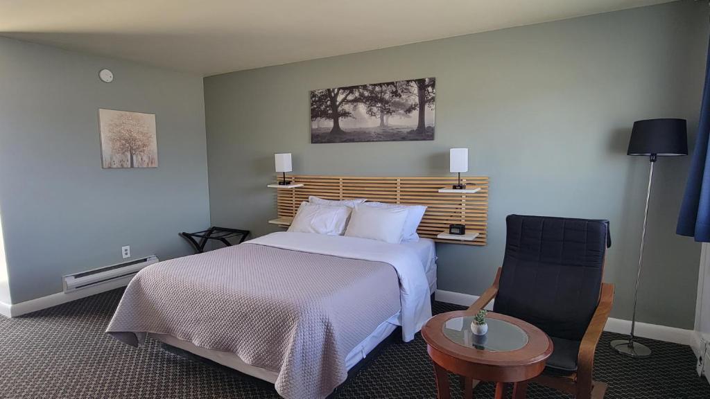 a hotel room with a bed and a chair at Lord Nelson Motel in Kingston