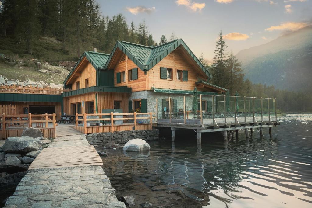 ein Haus auf einer Anlegestelle im Wasser in der Unterkunft Rifugio Lago Malghette in Madonna di Campiglio