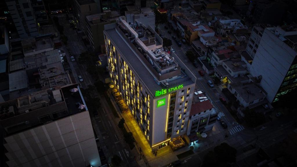 リマにあるibis styles Lima San Isidroの緑の看板が立つ建物の頭上