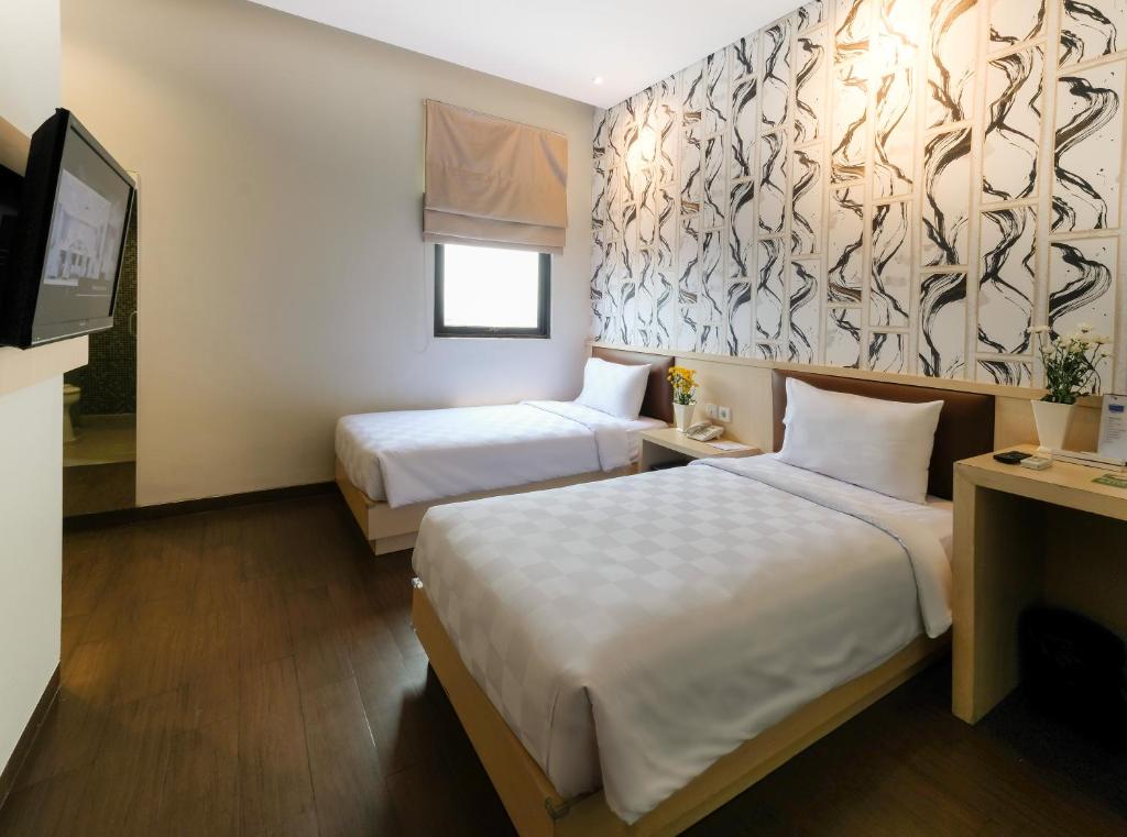 A bed or beds in a room at Hotel 88 Mangga Besar 62 Lokasari By WH