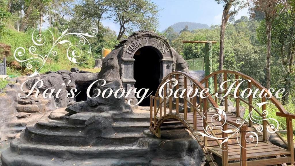 una casa gotica scavata nella roccia con una piccola porta e scale di Rai’s Coorg Cave House a Madikeri