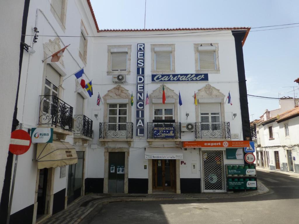 een wit gebouw met een bord op een straat bij Residencial Carvalho in Estremoz