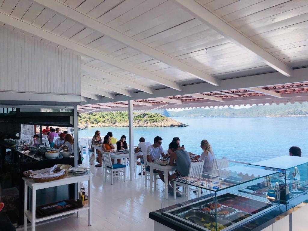 personnes assises à table dans un restaurant au bord de l'eau dans l'établissement Nur Beach Hotel, à Kaş