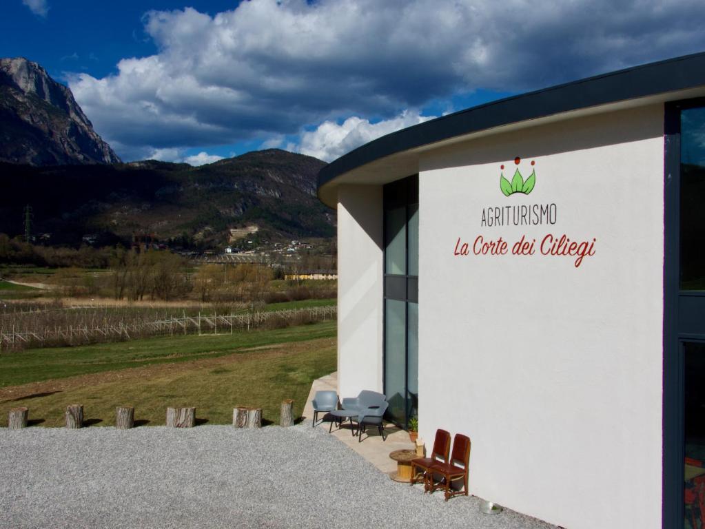 Agritur La Corte dei Ciliegi في ترينتو: مبنى ابيض عليه كراسي وعلامة