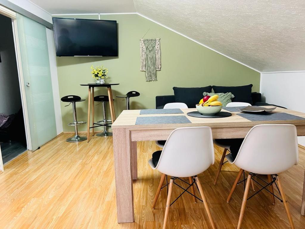 a living room with a table and white chairs at Apartment Buga Bilje in Bilje